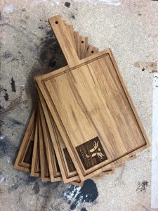 Solid wood chopping board including handle and bespoke engraved company logo