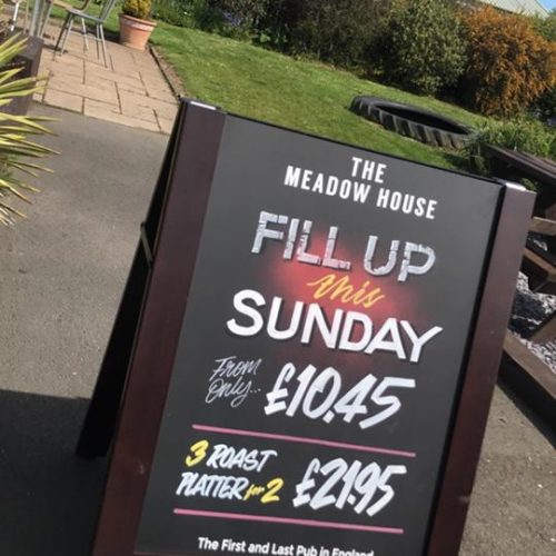 Pavement sign with chalkboards that slot out and can be reversed showing optional printed side outside of a pub
