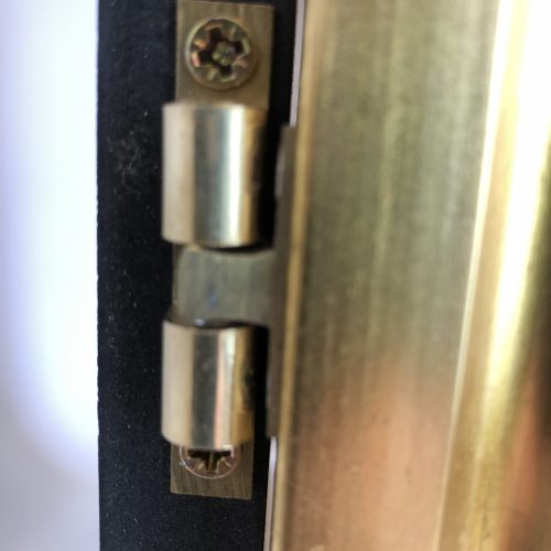Wooden poster frame with gold frame closeup of hinges and finish
