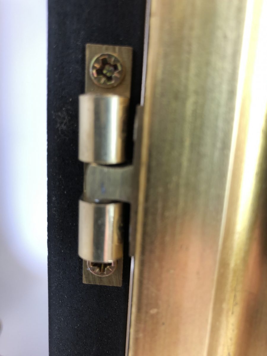 Wooden poster frame with gold frame closeup of hinges and finish