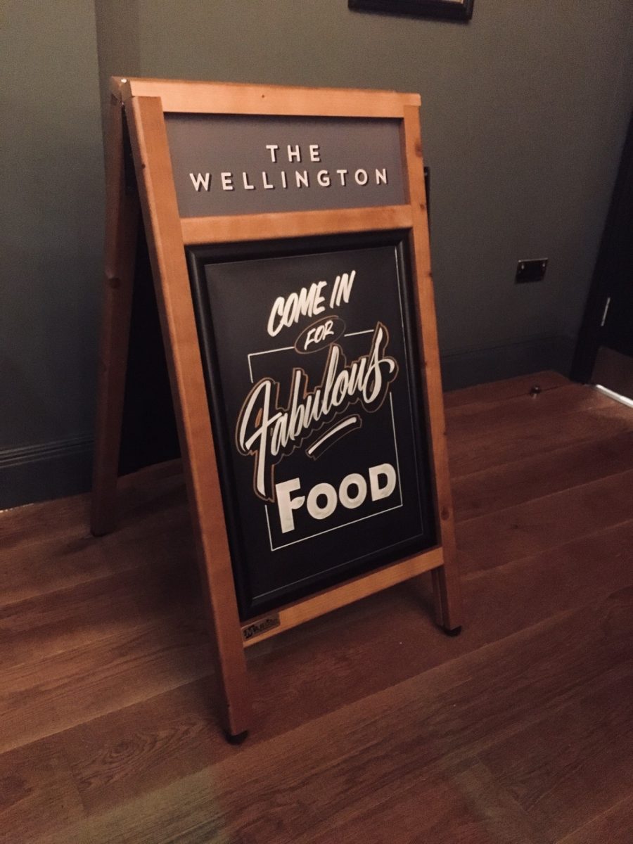 Standard Plus wooden sign with chalkboard display in situ at a pub