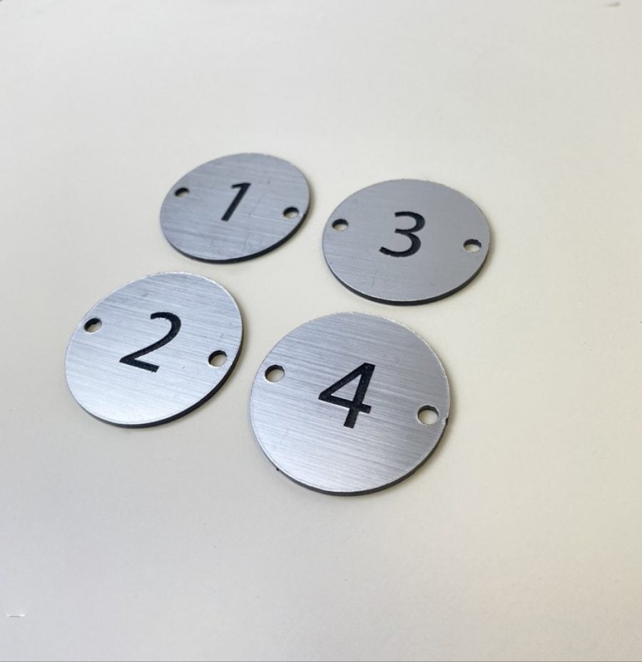 Small round metal looking disc with a table numbers