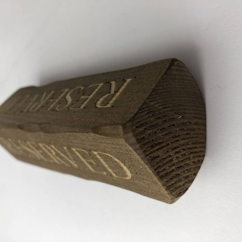 A wooden block with Reserved engraved for table reservations