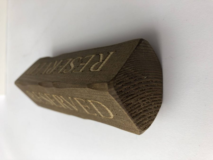 A wooden block with Reserved engraved for table reservations